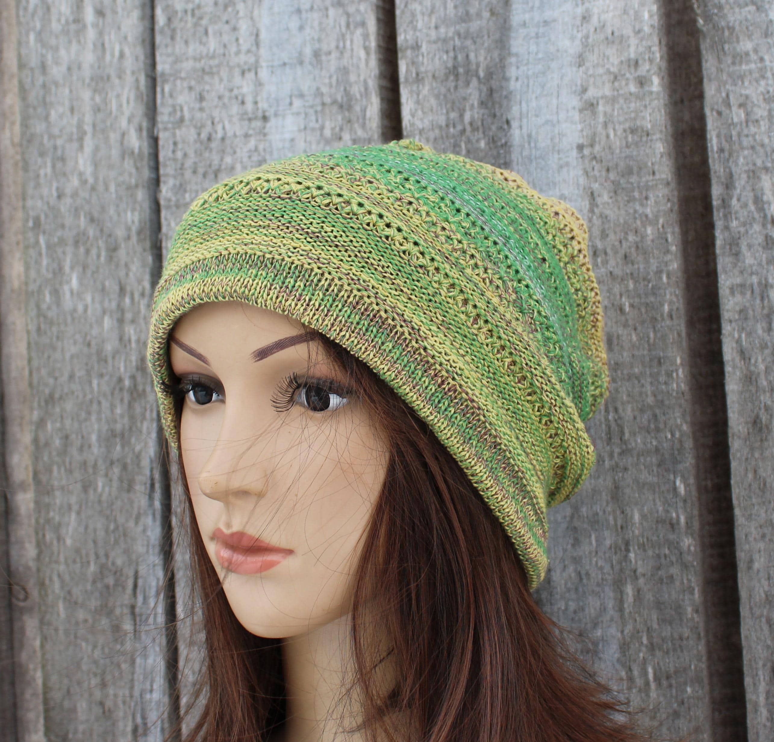 Green knitted hat on a mannequin head against a wooden background