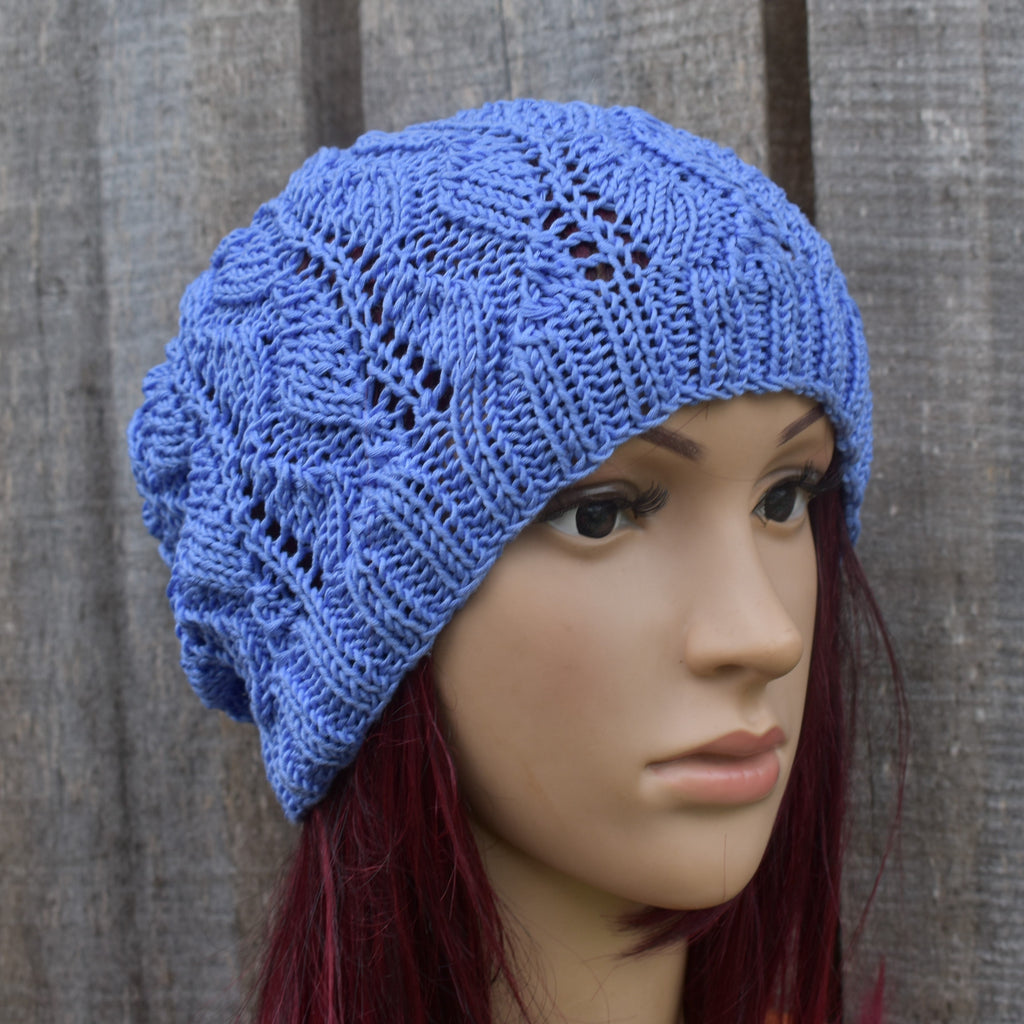 Blue knitted hat on a mannequin head against a gray background