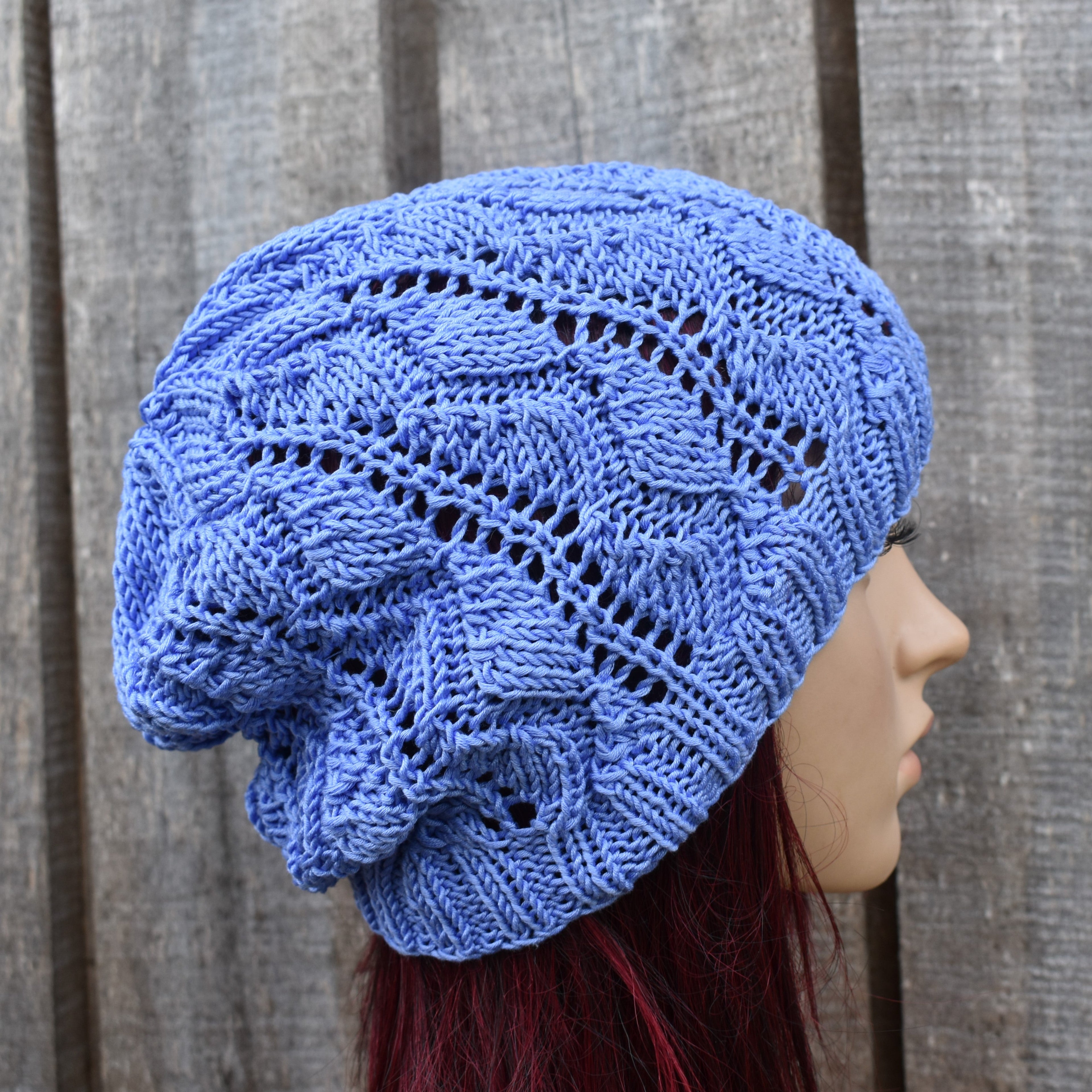 Blue knitted beanie on a mannequin head against a wooden background