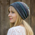 Woman wearing a colorful knit beanie against a wooden background