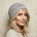 Woman wearing a gray knit beanie against a textured beige background