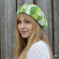 Woman wearing a green and white patterned knit hat against a wooden background
