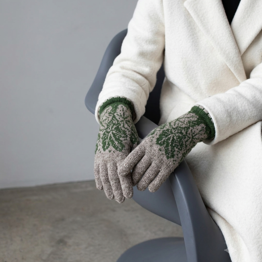 Person wearing patterned gloves and a white coat sitting on a chair.