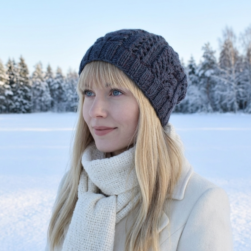 Woman wearing a knitted hat and scarf in a snowy landscape