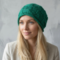 Woman wearing a green knitted hat against a gray background