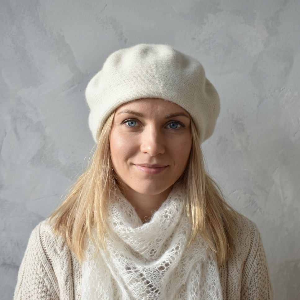 Woman wearing a white beret and scarf against a gray background