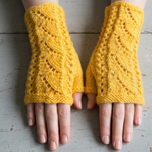 Yellow knitted fingerless gloves on a light wooden surface