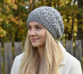 Woman wearing a gray knit beanie with a blurred natural background