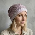 Woman wearing a pink knit beanie against a gray background