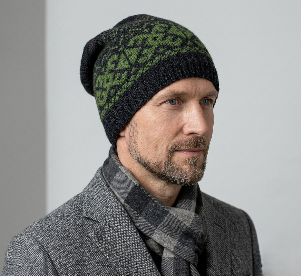 Man wearing a black and green patterned beanie and gray scarf against a light gray background