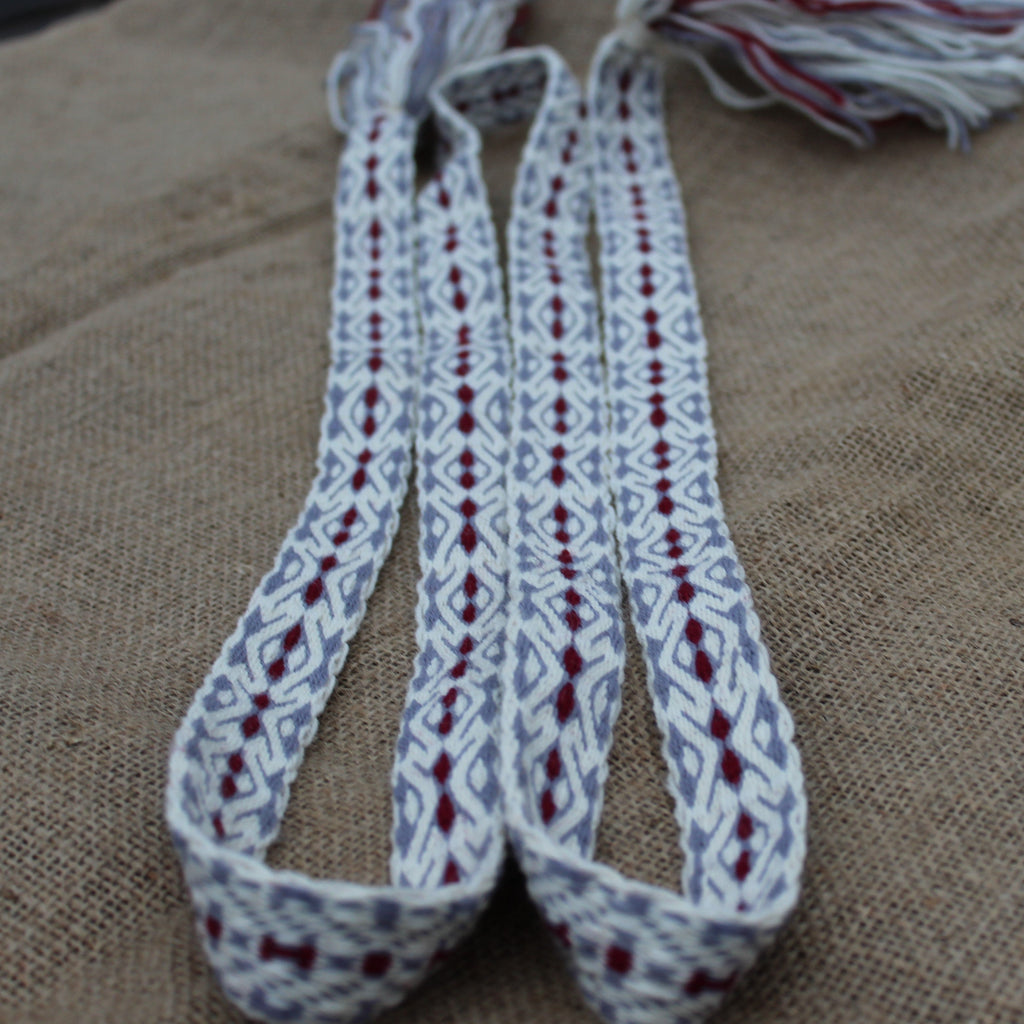 Woven strap with a geometric pattern on a textured fabric background