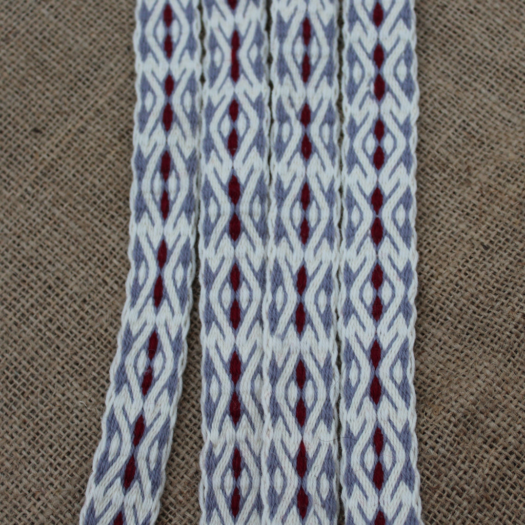 Textile with gray and red pattern on a brown fabric background