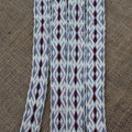 Textile with gray and red pattern on a brown fabric background
