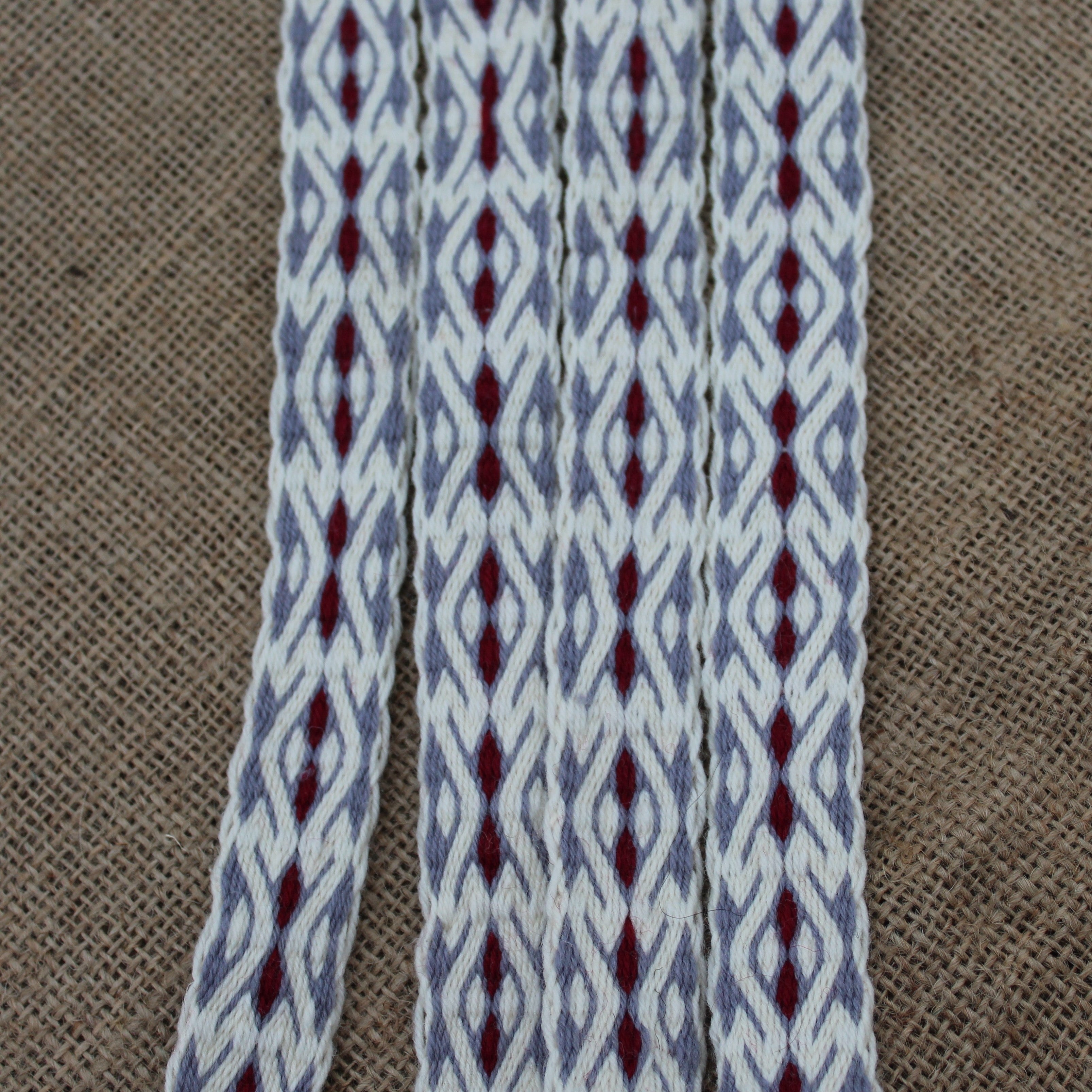 Textile with gray and red pattern on a brown fabric background