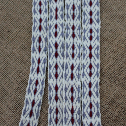 Textile with gray and red pattern on a brown fabric background