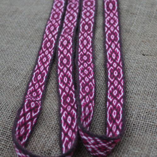  Red patterned belt on a textured gray background