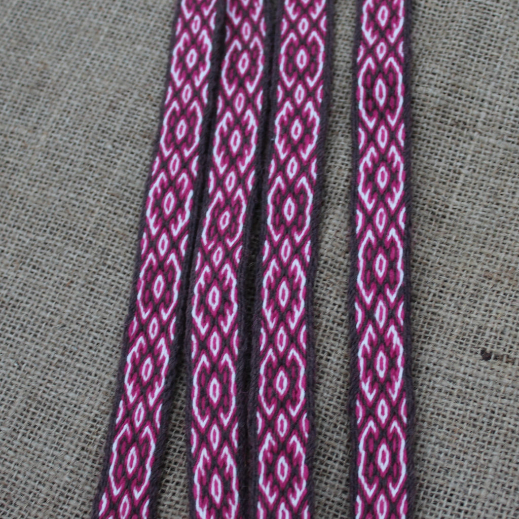 Close-up of a red patterned cord on a gray fabric background