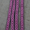 Close-up of a red patterned cord on a gray fabric background