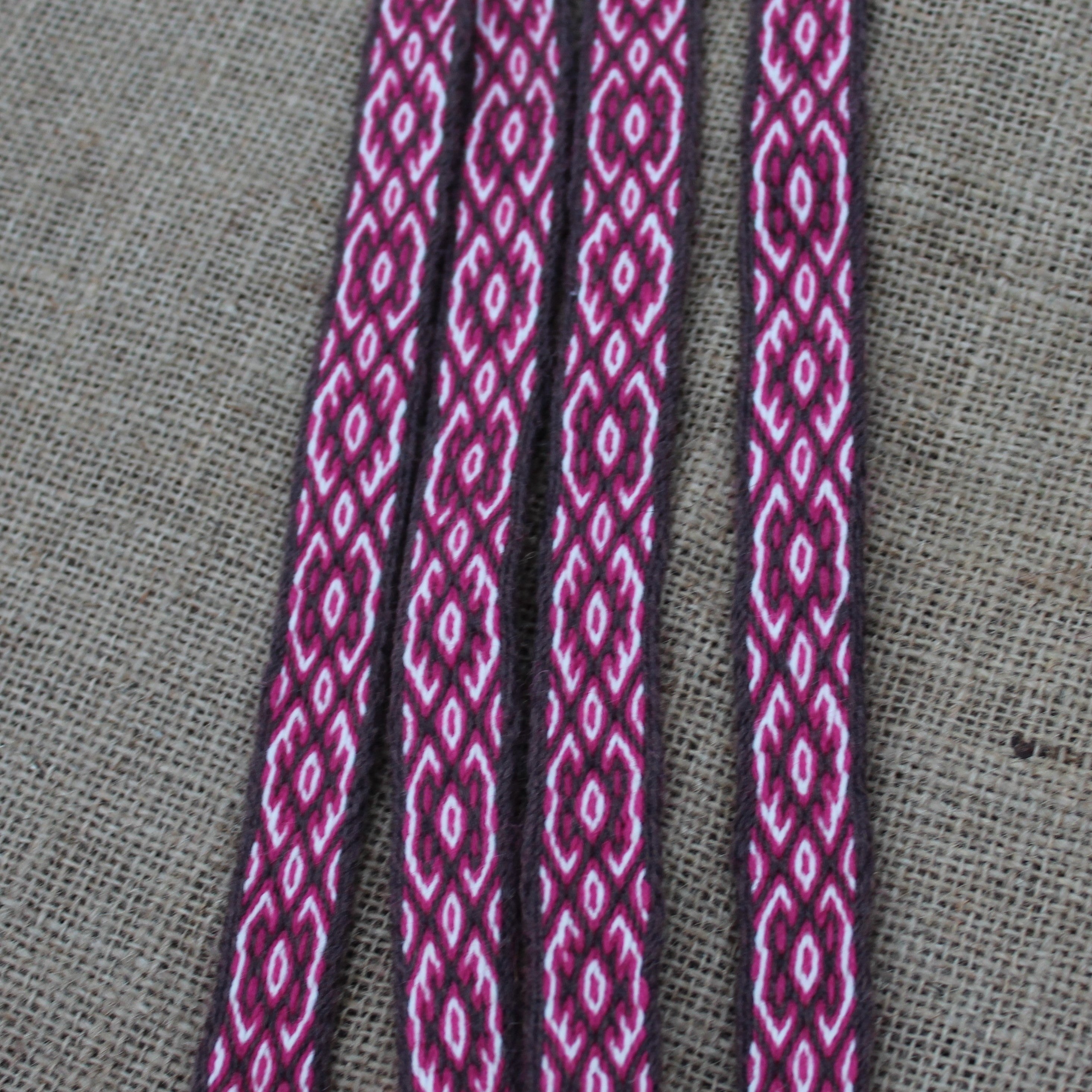 Close-up of a red patterned cord on a gray fabric background