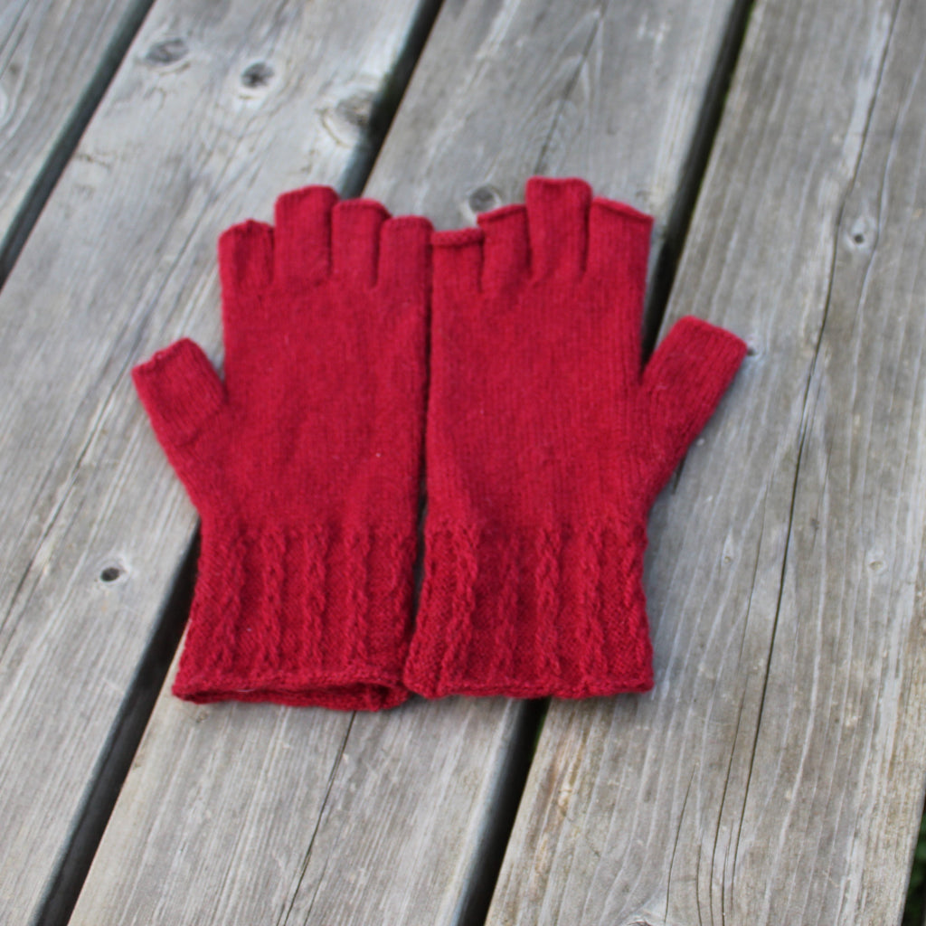 Red fingerless gloves on a wooden surface