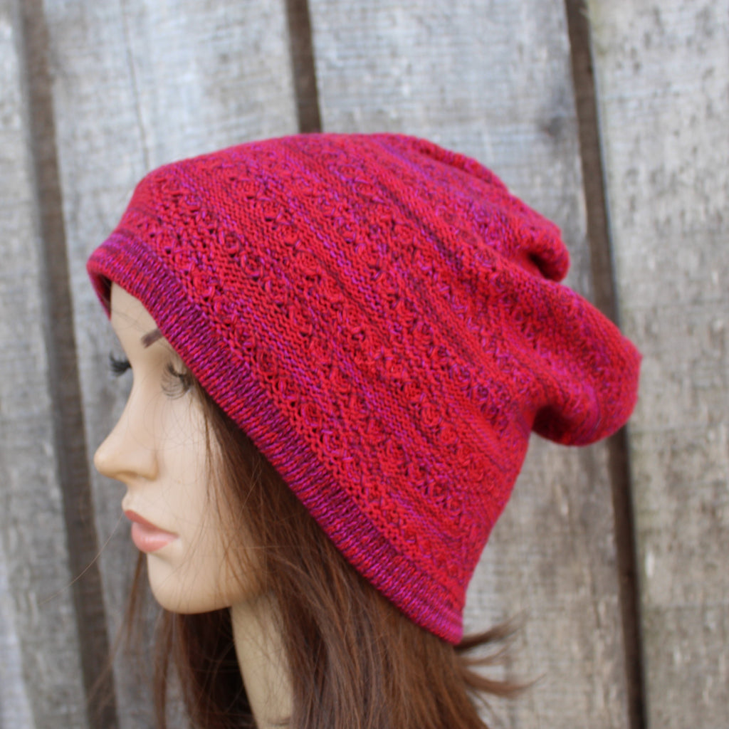 Red knitted hat on a mannequin head against a wooden background