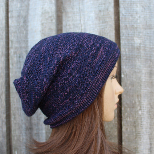Person wearing a blue knitted beanie against a wooden fence background