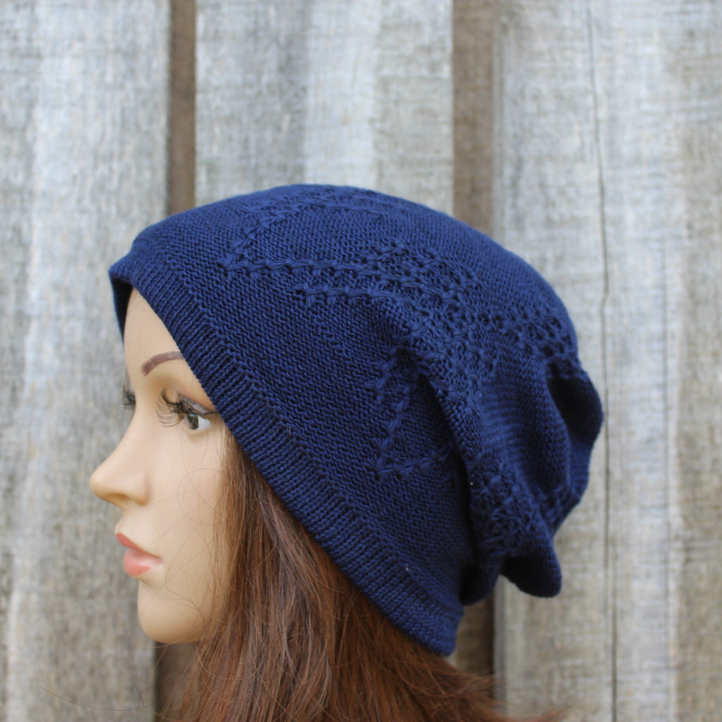 Navy blue knitted beanie on a mannequin head against a wooden background