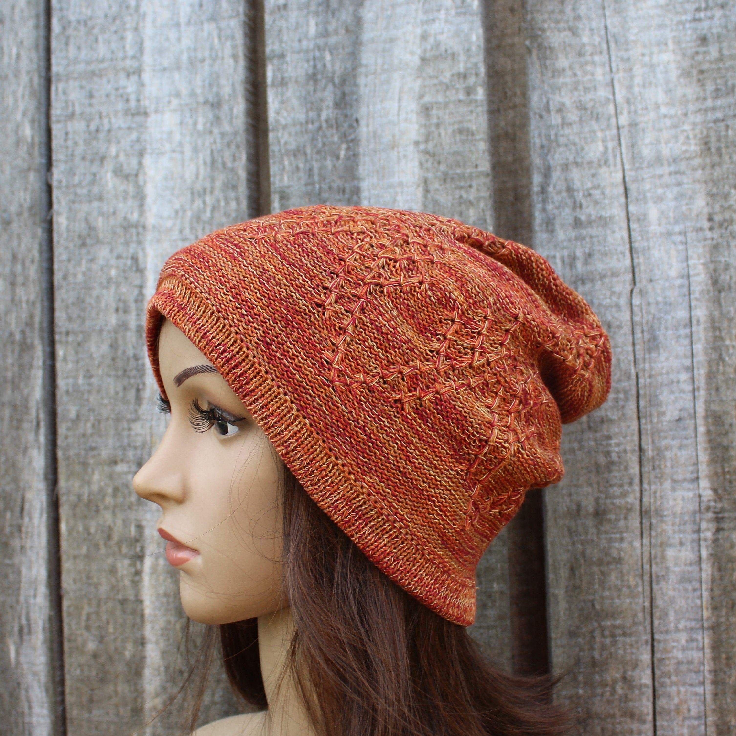 Knitted beanie on a mannequin head against a wooden background