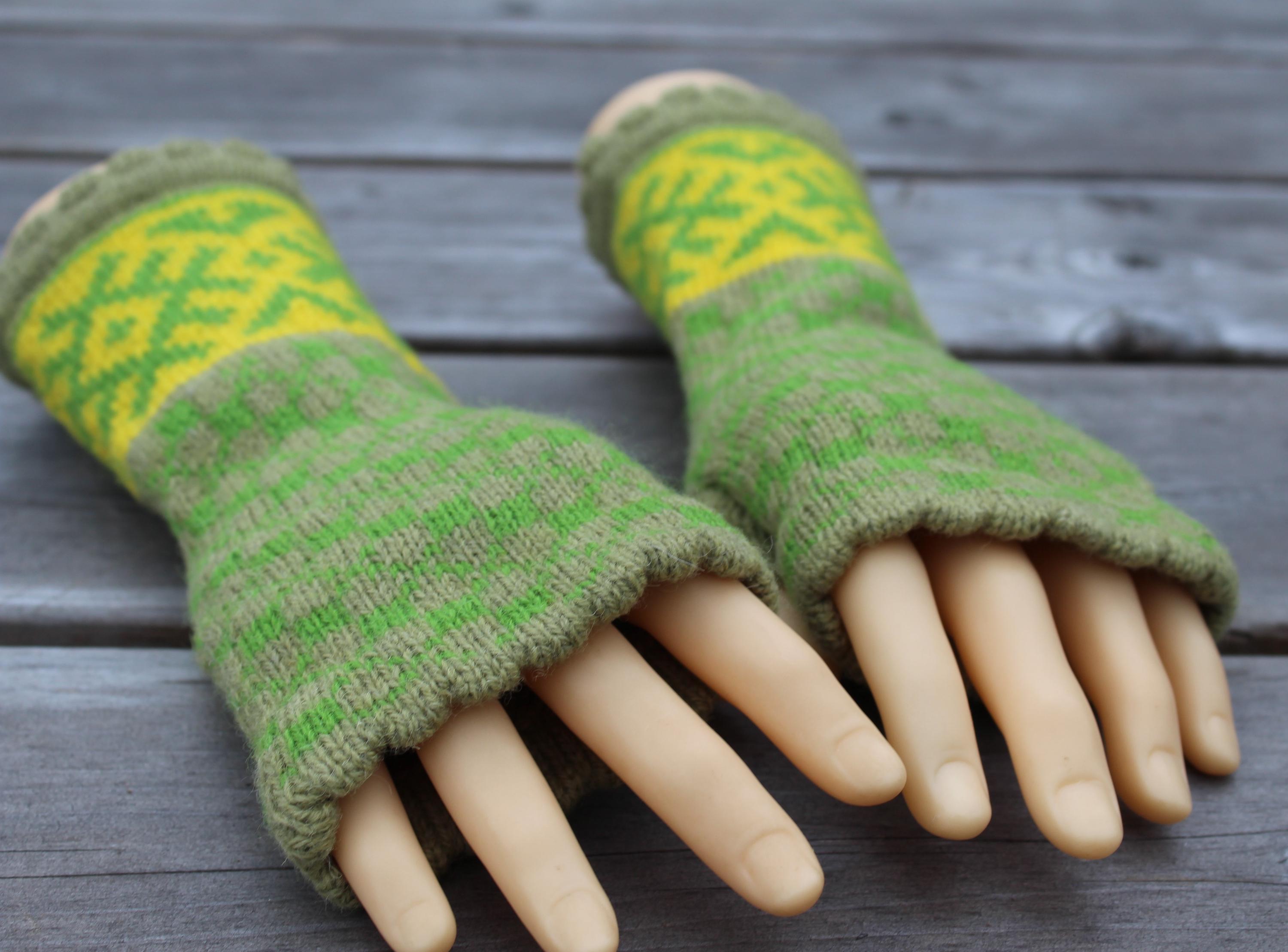 Green and yellow patterned fingerless gloves on a wooden surface