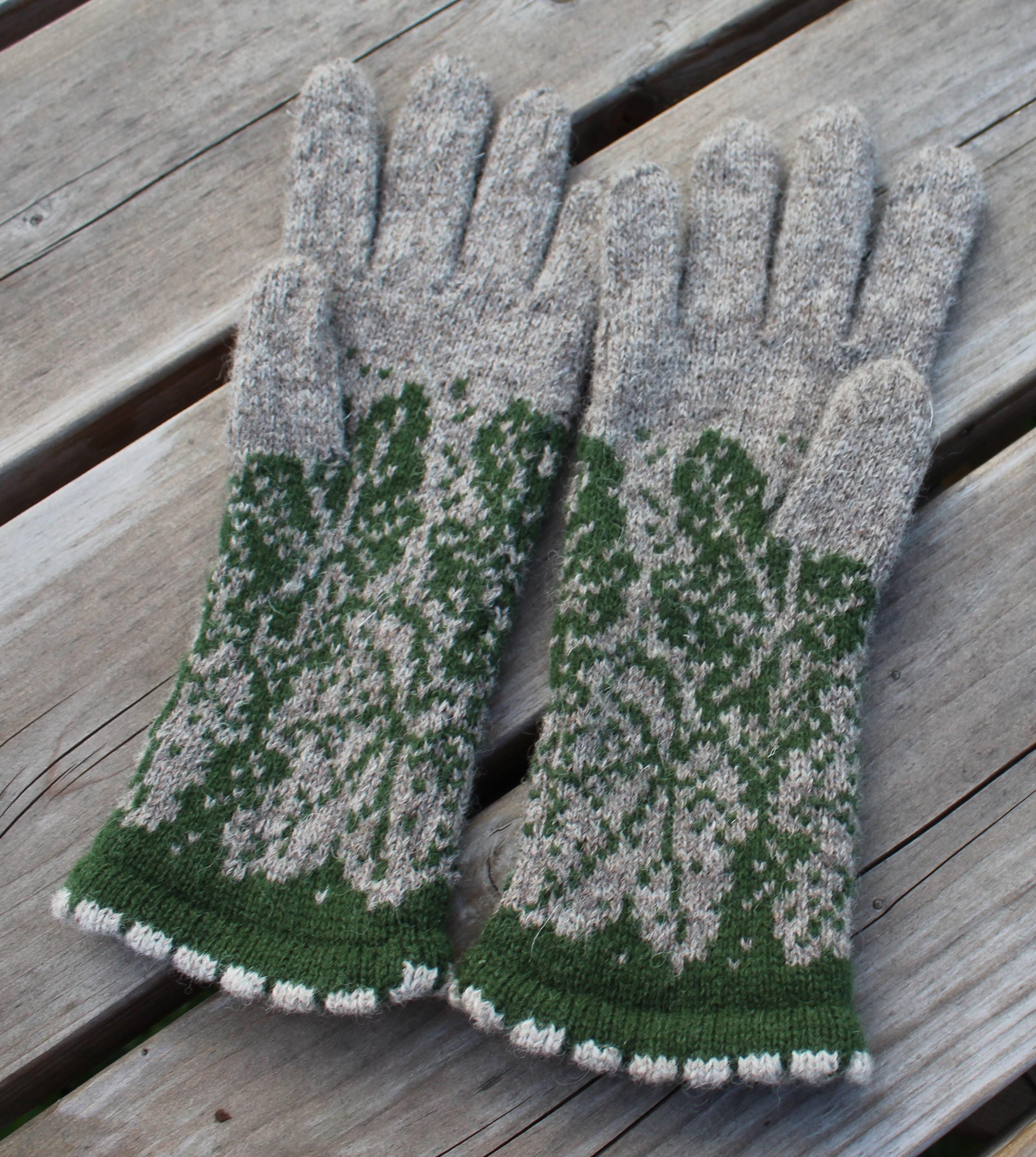 Pair of green and gray gloves on a wooden surface