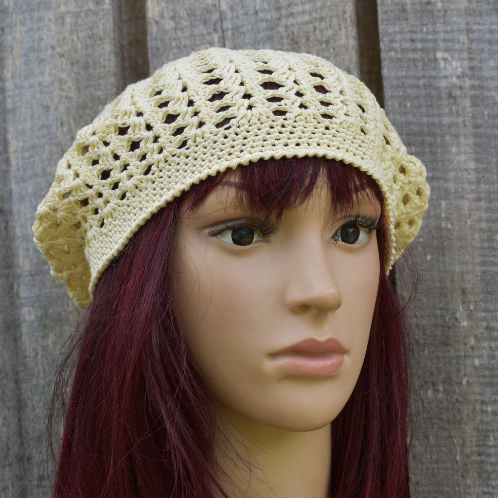 Beige crochet hat on a mannequin head against a wooden background
