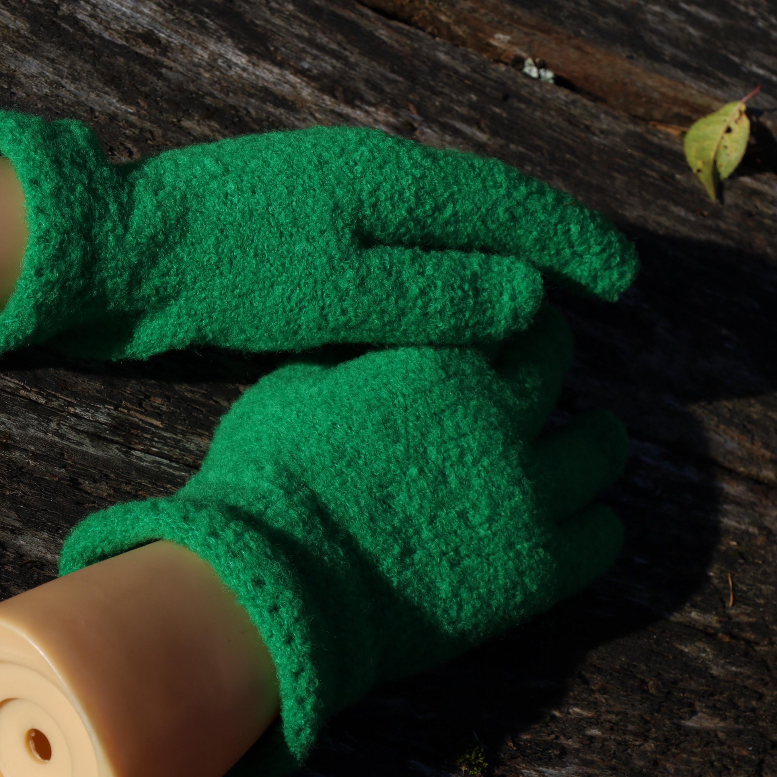 Green finger gloves on a wooden surface