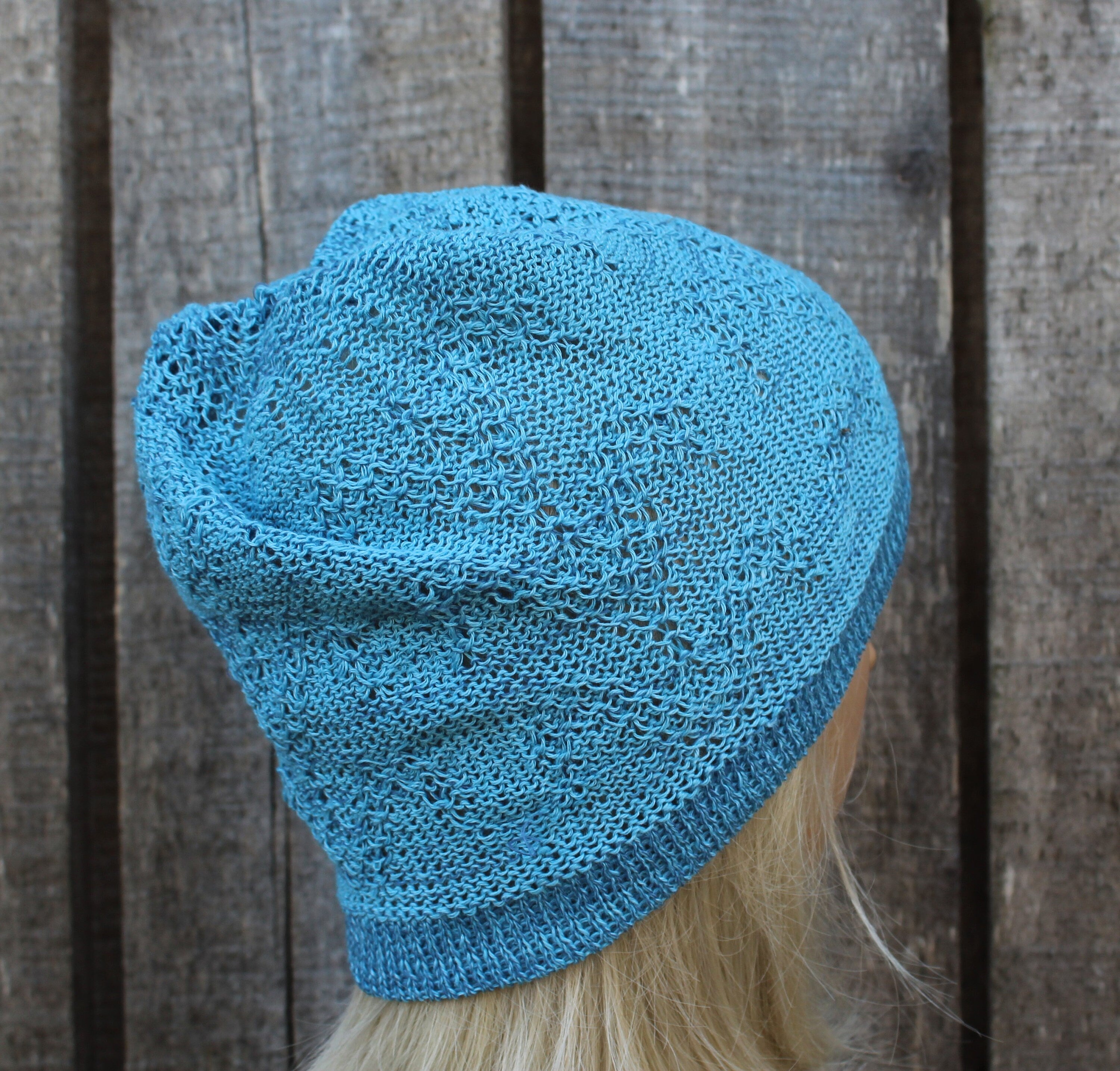 Blue knitted beanie on a wooden background