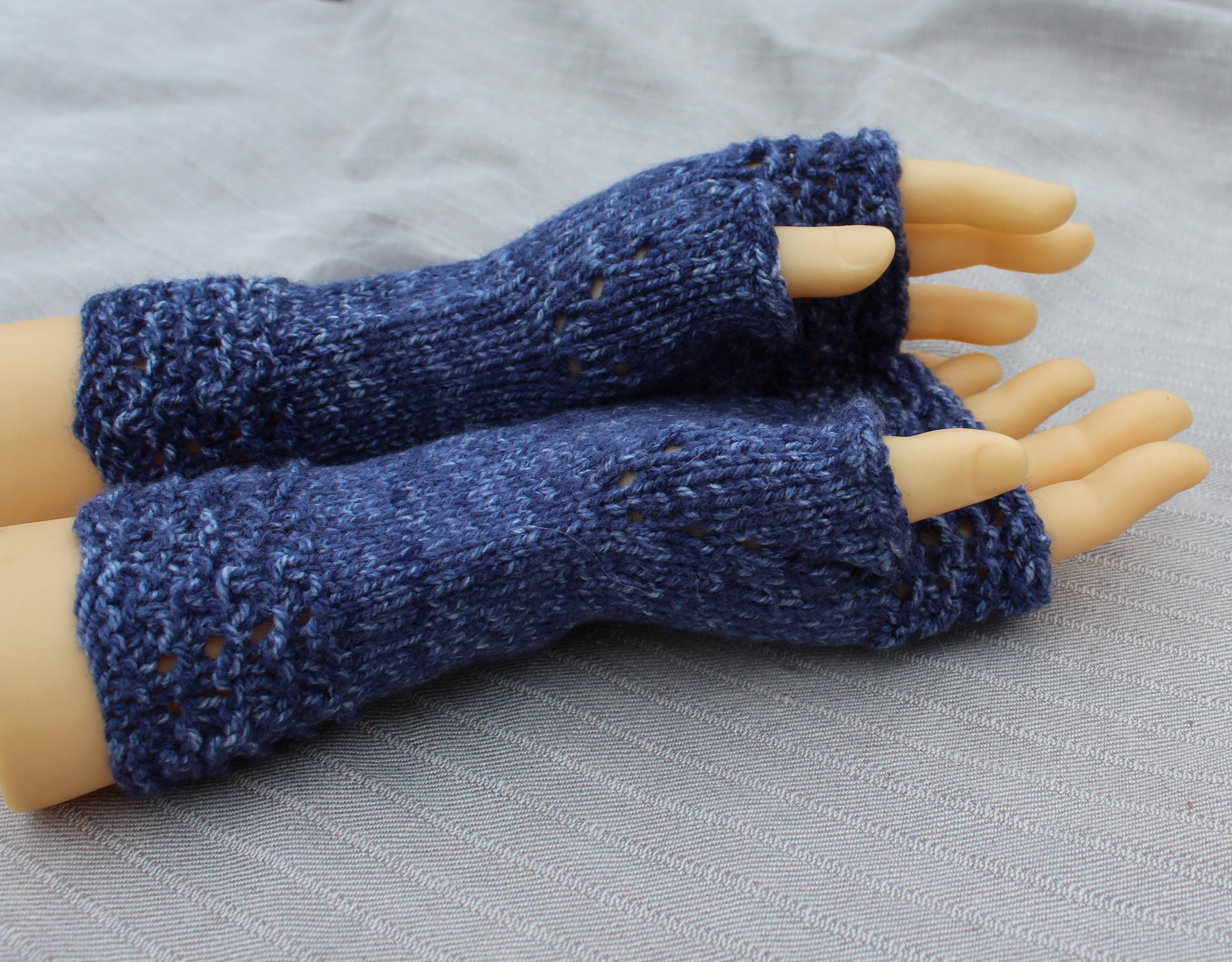 Blue knitted fingerless gloves on a mannequin hand against a gray background