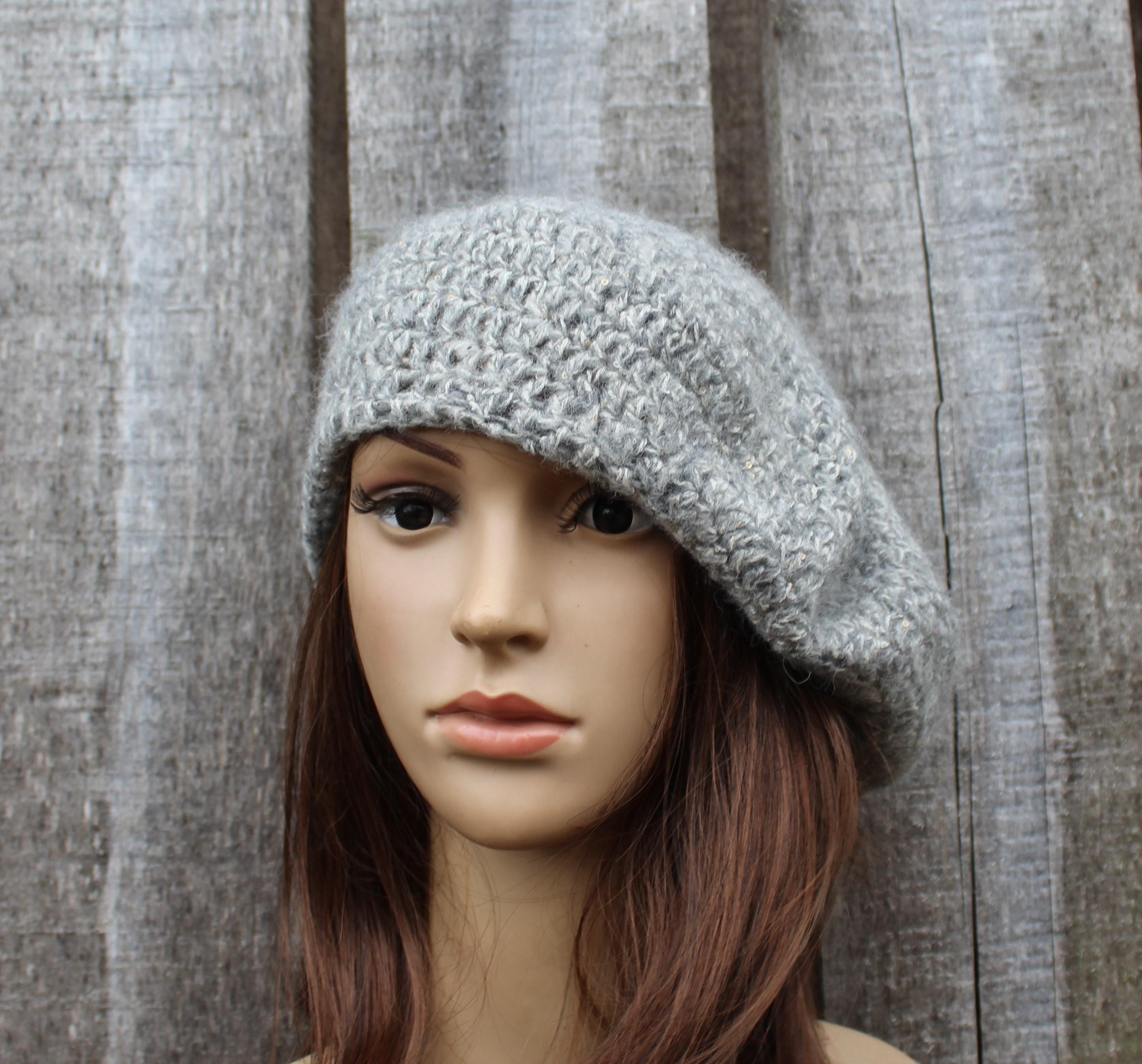 Mannequin head wearing a gray knit beanie against a wooden panel background
