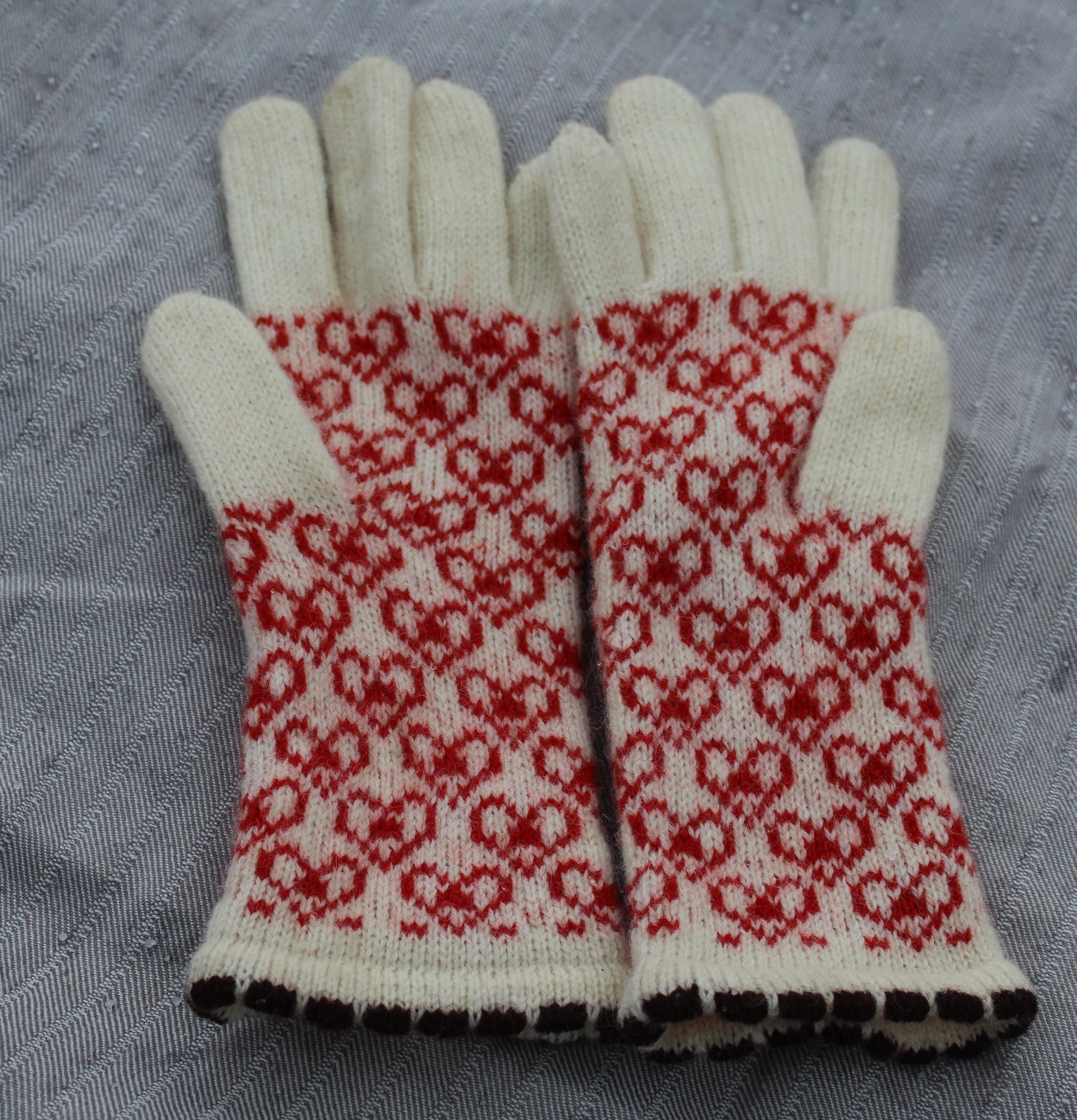 Pair of gloves with red and white pattern on a gray background