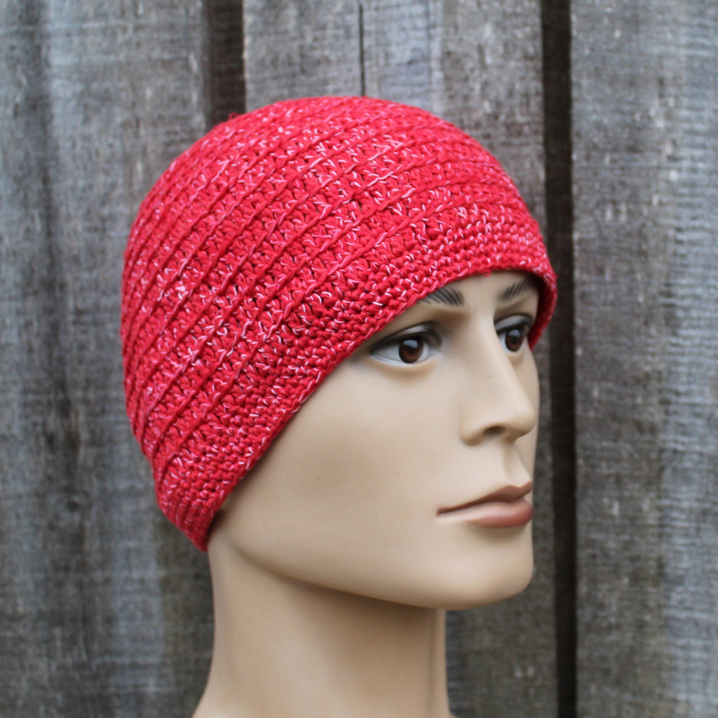 Red knitted beanie on a mannequin head against a wooden background