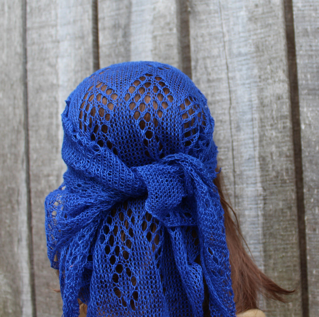 Blue knitted headscarf on a person with a wooden background