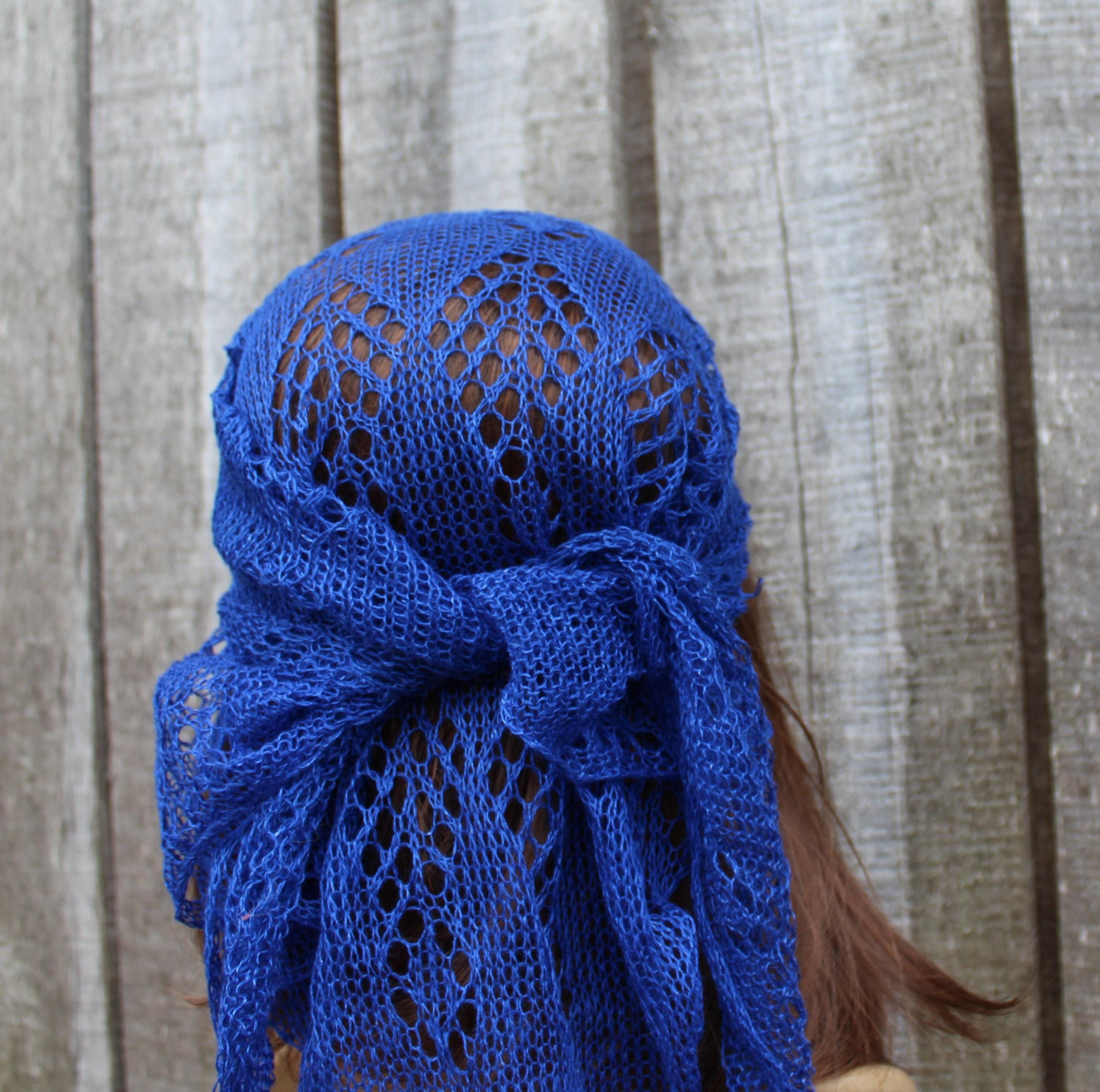Blue knitted headscarf on a person with a wooden background