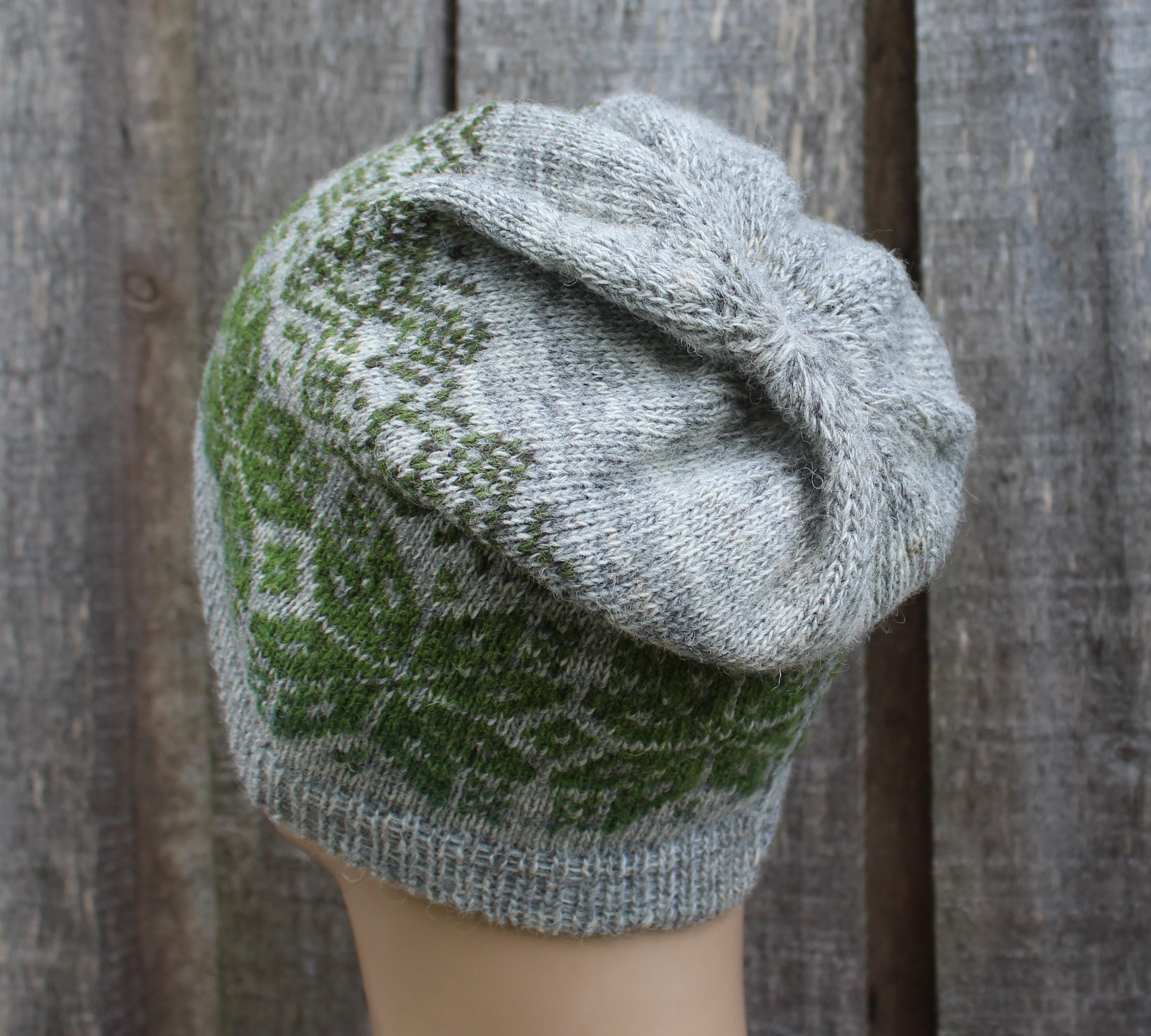 Knitted hat with green and gray pattern against a wooden background