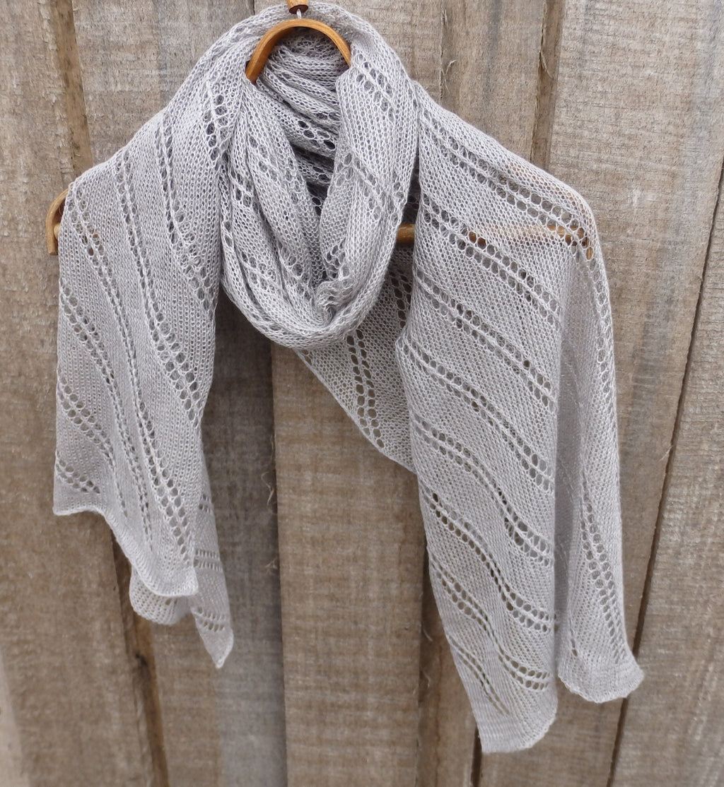 Knitted shawl draped over a wooden surface