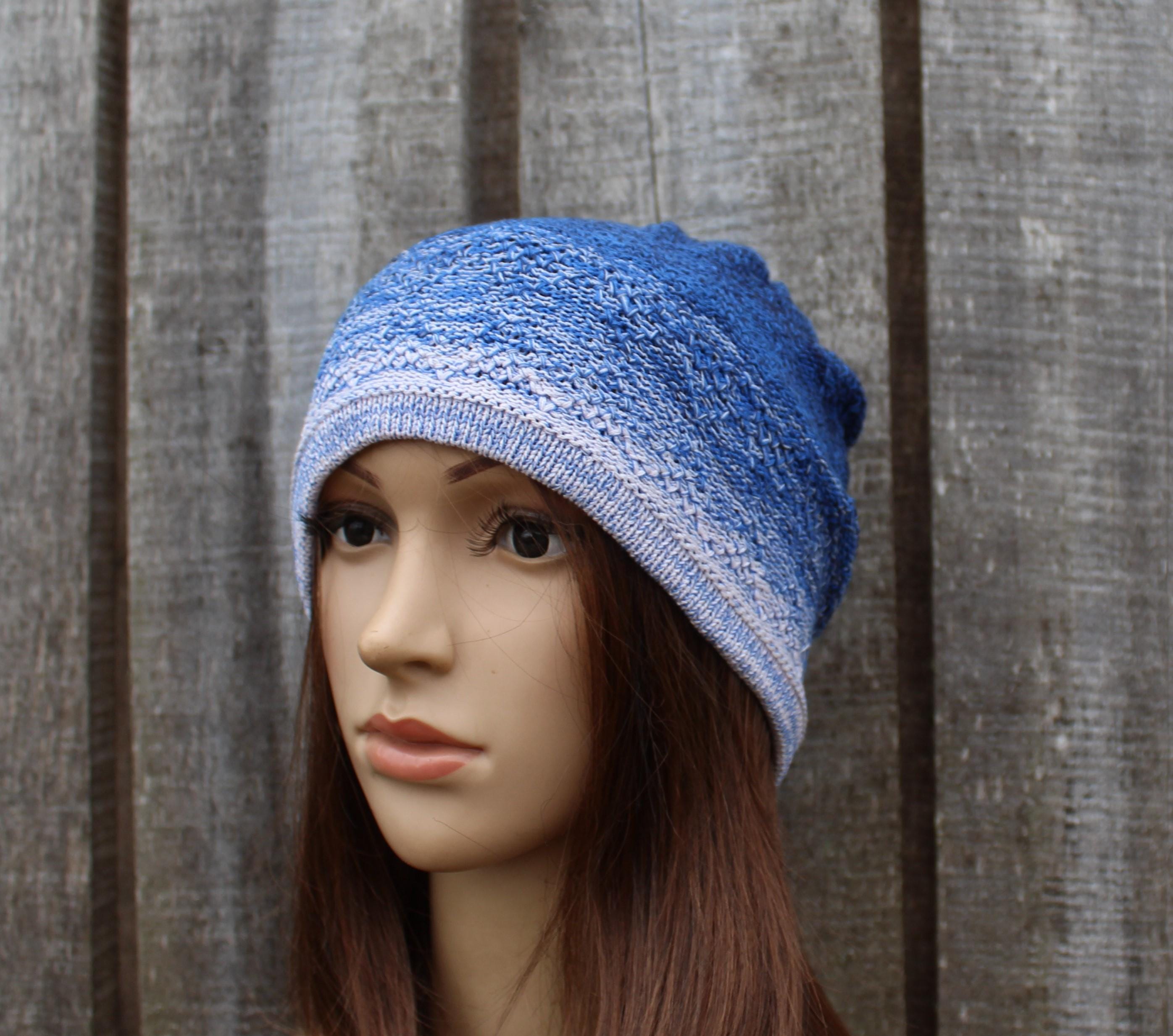 Blue knitted beanie on a mannequin head against a wooden background