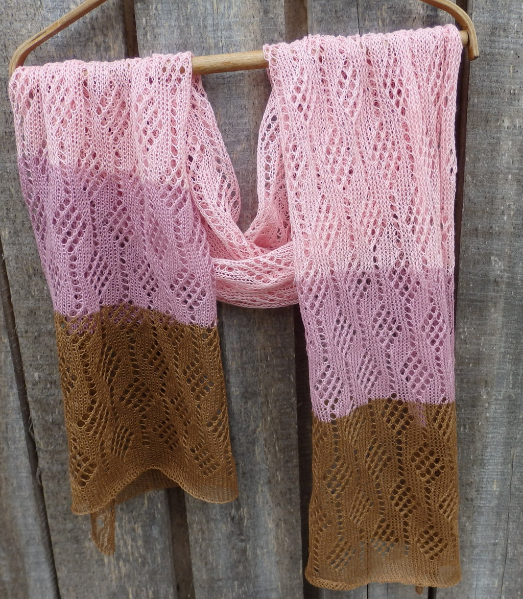 Knitted scarf with pink and brown gradient on a wooden background