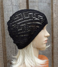 Black knit beanie worn by a mannequin against a wooden background