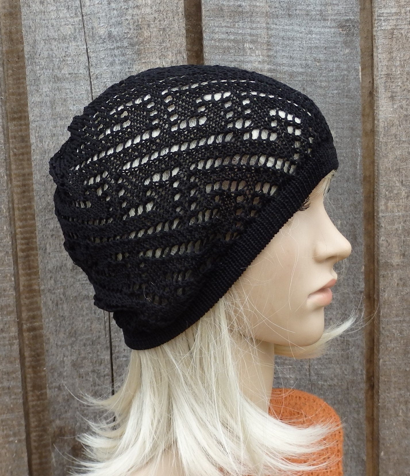 Black knit beanie worn by a mannequin against a wooden background