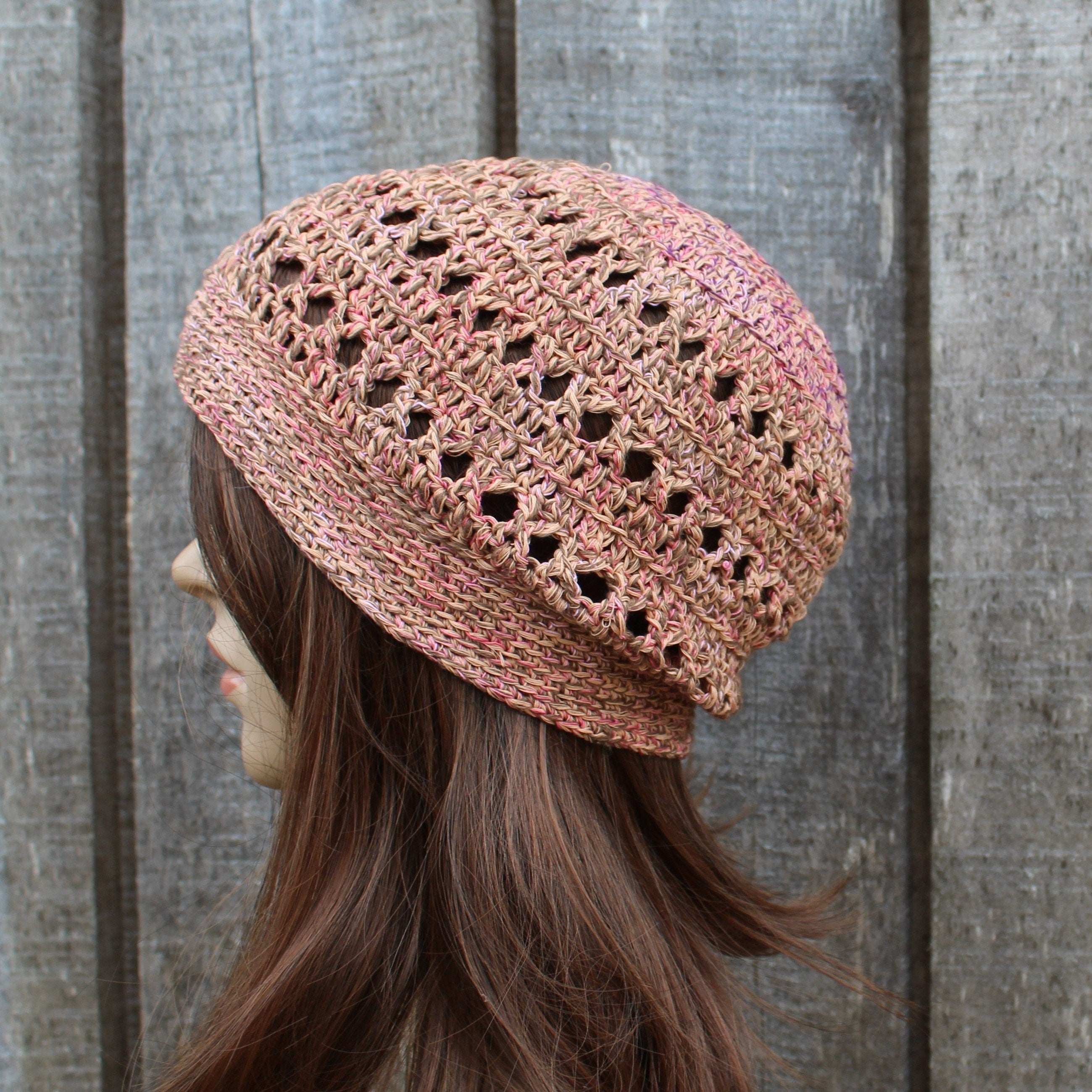 orange brown crochet hat worn by a person against a wooden background