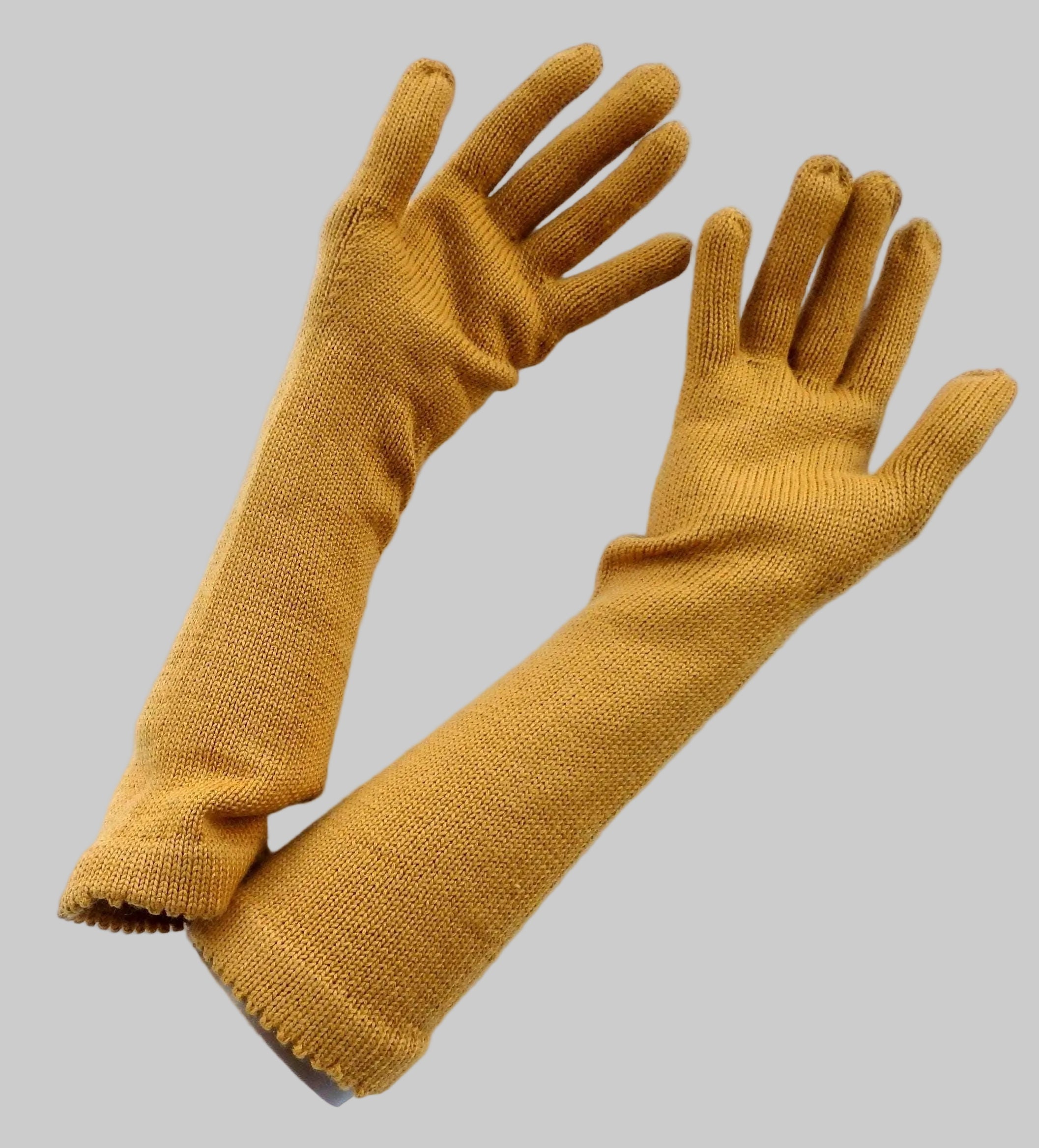 Pair of mustard yellow gloves on a white background