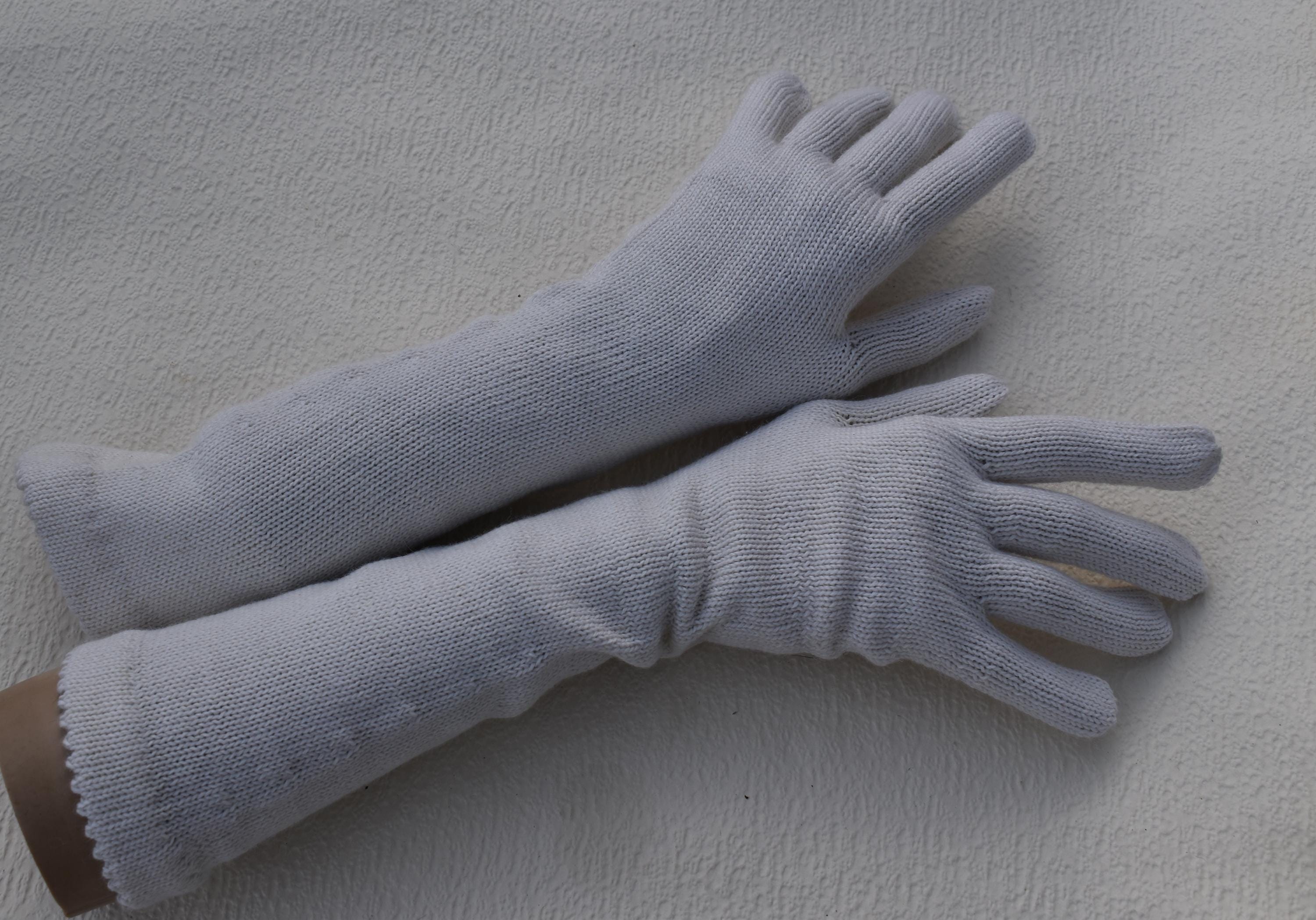Pair of white gloves on a light gray background