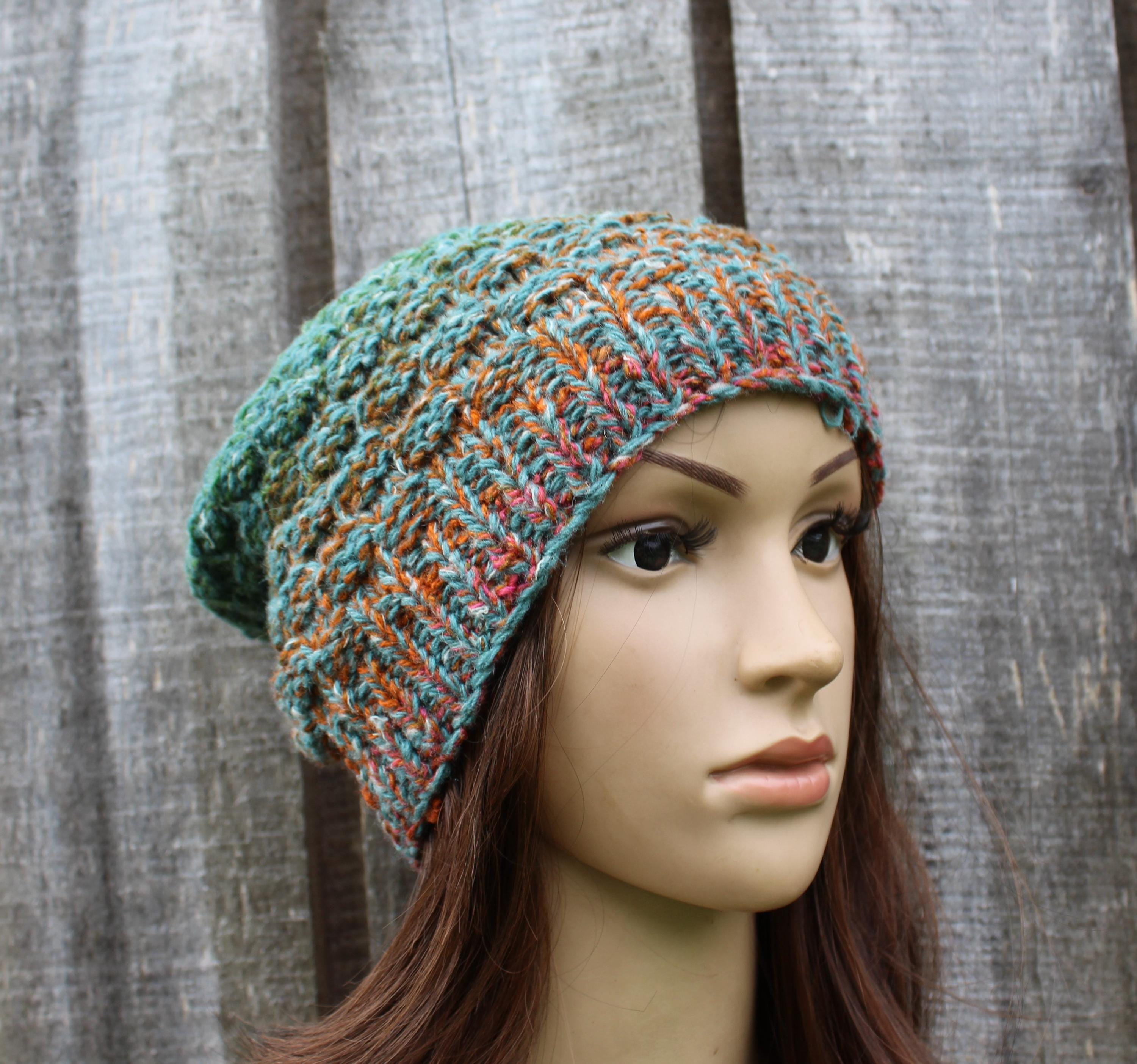 Multicolored knitted beanie on a mannequin head against a textured gray background