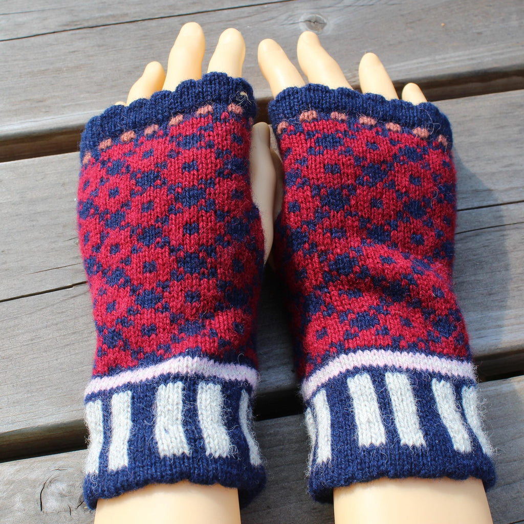 Pair of blue and red patterned fingerless gloves on a wooden surface